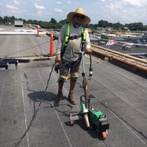 Employee Wearing his Safety Harness with Retractable Near Edge of Roof