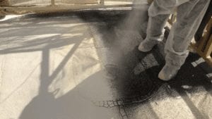 worker spraying foam on flat roof